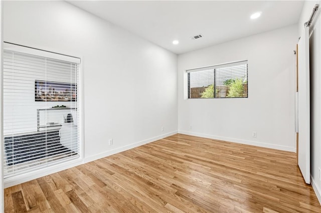 spare room featuring light wood finished floors, baseboards, and recessed lighting