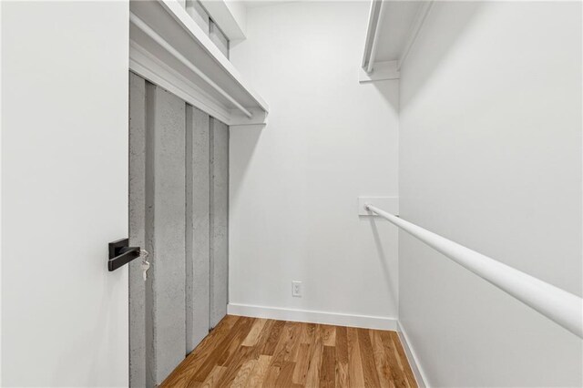 unfurnished bedroom featuring connected bathroom, hardwood / wood-style flooring, and a barn door