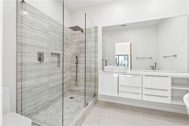 full bath featuring a walk in shower, double vanity, toilet, and tile patterned flooring