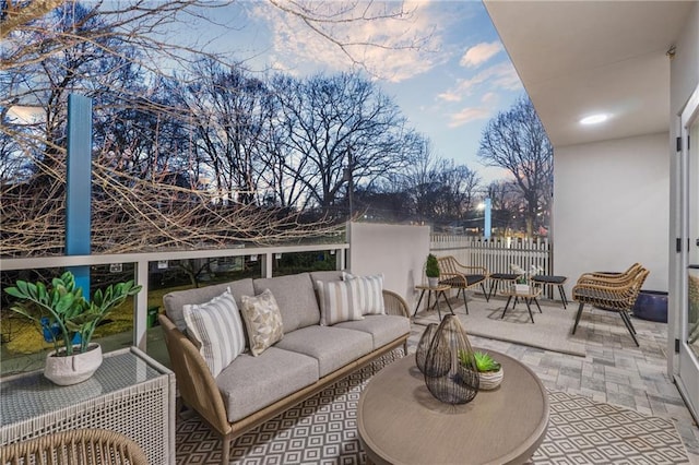 view of patio with outdoor lounge area, a balcony, and fence