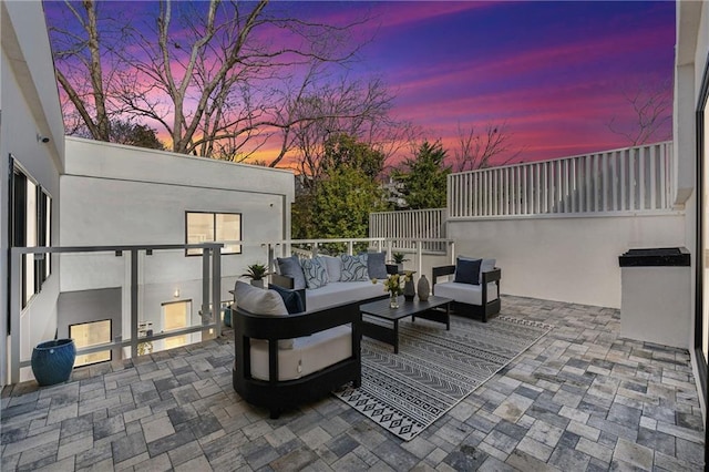 patio terrace at dusk featuring an outdoor hangout area