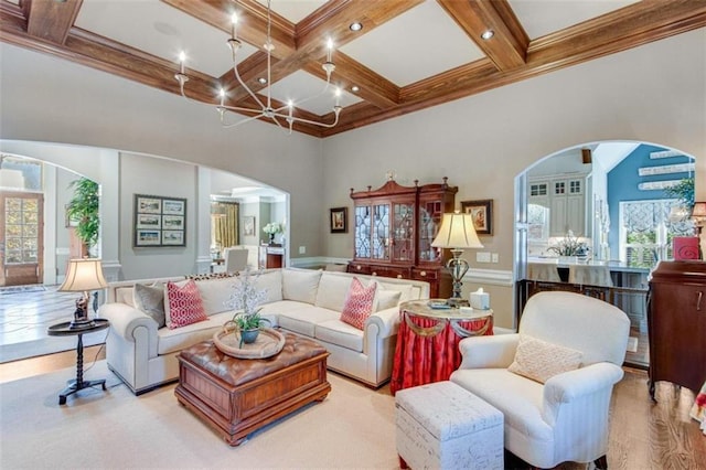 living room with beam ceiling, a wealth of natural light, a towering ceiling, and coffered ceiling