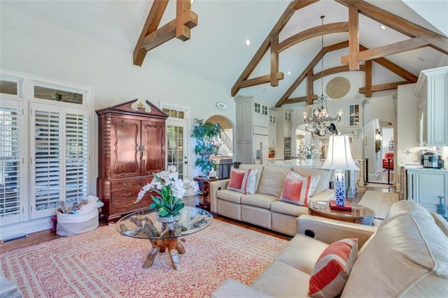 living room featuring a chandelier, beam ceiling, hardwood / wood-style flooring, and high vaulted ceiling