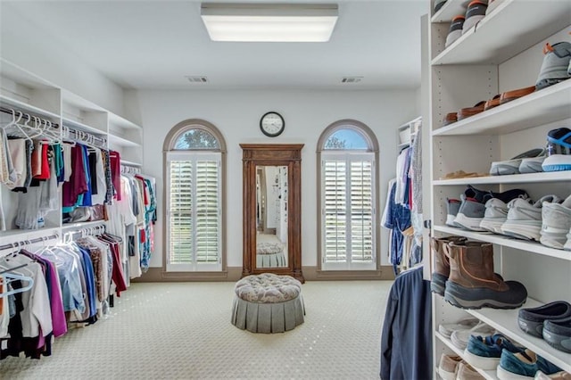 walk in closet featuring light colored carpet