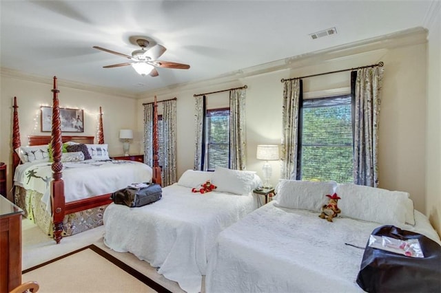 carpeted bedroom with ceiling fan and ornamental molding