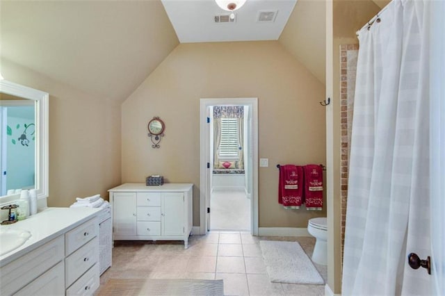 bathroom featuring tile patterned floors, vanity, toilet, and lofted ceiling