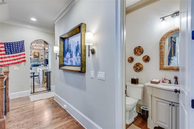 bathroom featuring hardwood / wood-style floors, vanity, toilet, and ornamental molding