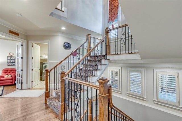 stairs featuring crown molding and wood-type flooring