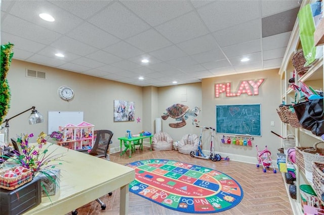 playroom with a drop ceiling and wood-type flooring