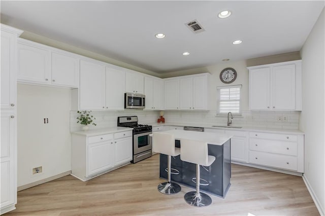 7653 Legacy Rd, Flowery Branch, GA 30542 - kitchen featuring appliances with stainless steel finishes, a sink, white cabinets, tasteful backsplash, and recessed lighting