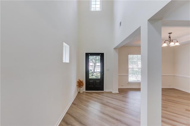 7653 Legacy Rd, Flowery Branch, GA 30542 - entrance foyer with plenty of natural light, light wood-type flooring, a chandelier, and a towering ceiling