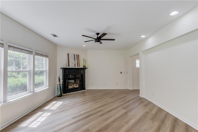 7653 Legacy Rd, Flowery Branch, GA 30542 - unfurnished living room with a ceiling fan, light wood-style floors, recessed lighting, a glass covered fireplace, and baseboards