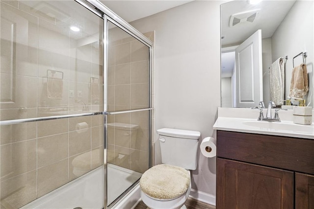 bathroom featuring visible vents, toilet, a stall shower, vanity, and baseboards