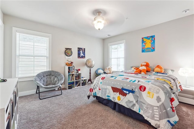 bedroom with carpet flooring, multiple windows, and ceiling fan