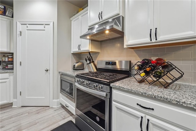 kitchen with white cabinetry, light hardwood / wood-style flooring, light stone countertops, and appliances with stainless steel finishes