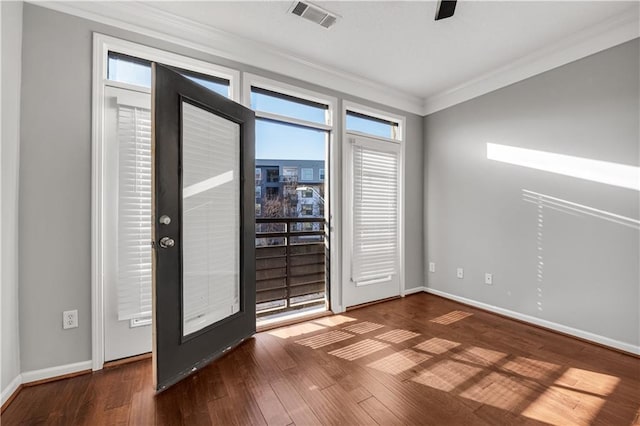 interior space with crown molding, a healthy amount of sunlight, and dark hardwood / wood-style flooring