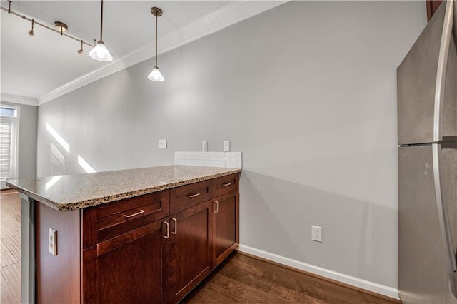 kitchen featuring hanging light fixtures, ornamental molding, stainless steel fridge, and kitchen peninsula