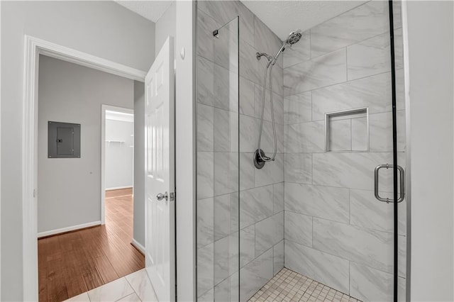 bathroom featuring an enclosed shower, hardwood / wood-style floors, and electric panel