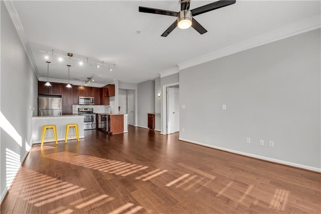 unfurnished living room featuring ornamental molding, dark hardwood / wood-style floors, sink, and ceiling fan