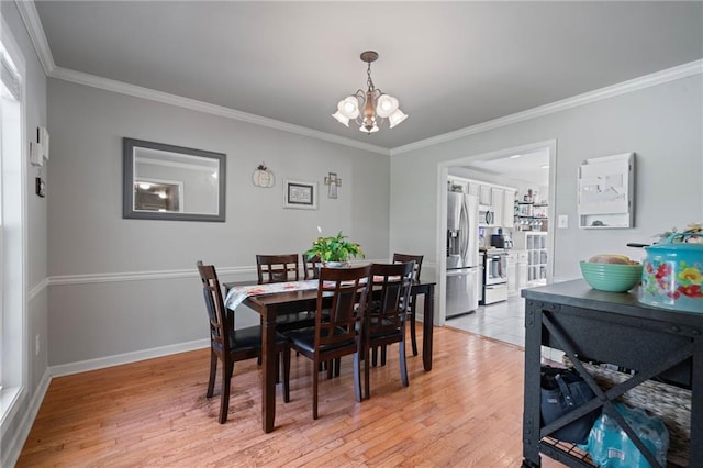 244 Bryn Brooke Dr, Dawsonville, GA 30534 - dining area with light wood finished floors, crown molding, a chandelier, and baseboards