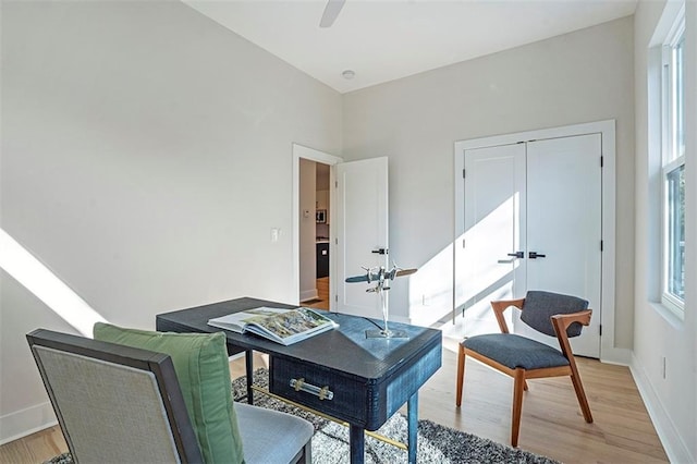 sitting room with baseboards, ceiling fan, and light wood finished floors