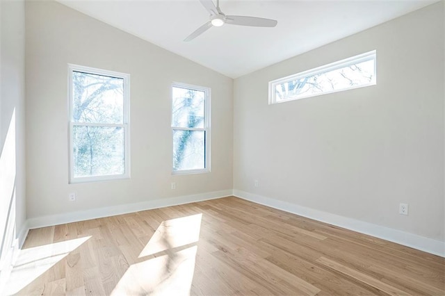 empty room with vaulted ceiling, plenty of natural light, and light wood finished floors