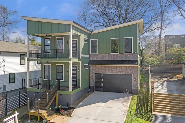 view of front of property featuring covered porch, board and batten siding, driveway, and fence