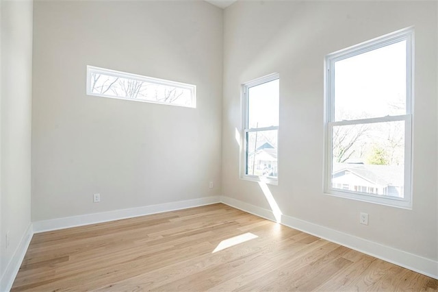 spare room featuring light wood-type flooring and baseboards