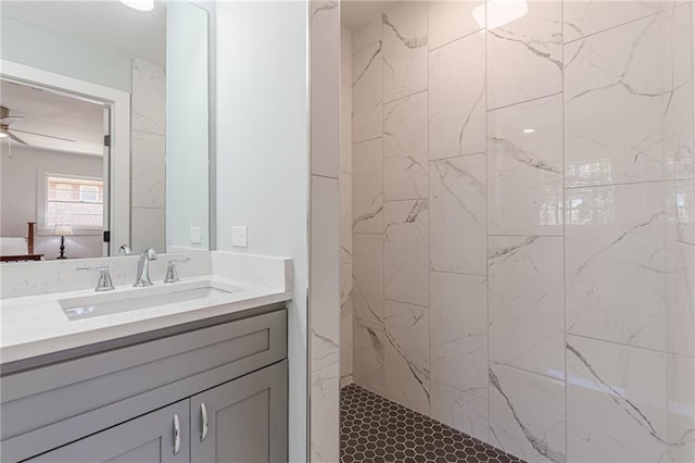 full bath featuring a marble finish shower, vanity, and ceiling fan