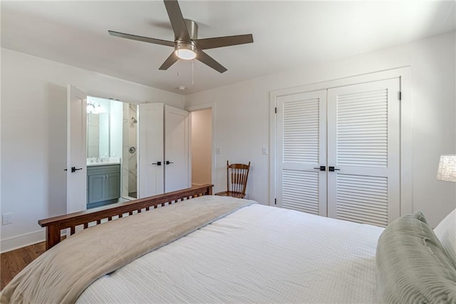 bedroom with a ceiling fan, baseboards, dark wood finished floors, a closet, and ensuite bathroom