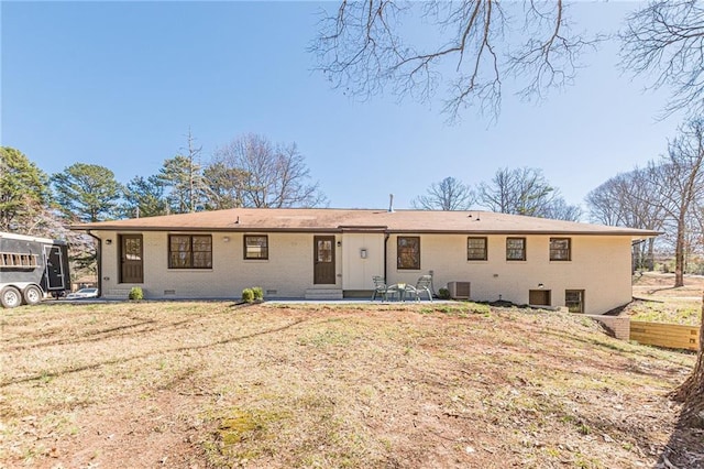 rear view of house featuring crawl space, brick siding, central AC, and a patio area