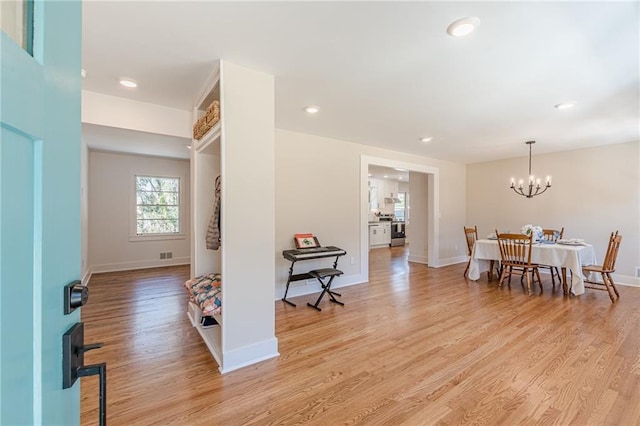 foyer entrance featuring visible vents, a notable chandelier, recessed lighting, light wood finished floors, and baseboards