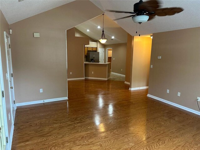 2191 Rockbridge Rd Unit 2603, Stone Mountain, GA 30087 - unfurnished living room featuring vaulted ceiling, a ceiling fan, dark wood-type flooring, and a textured ceiling