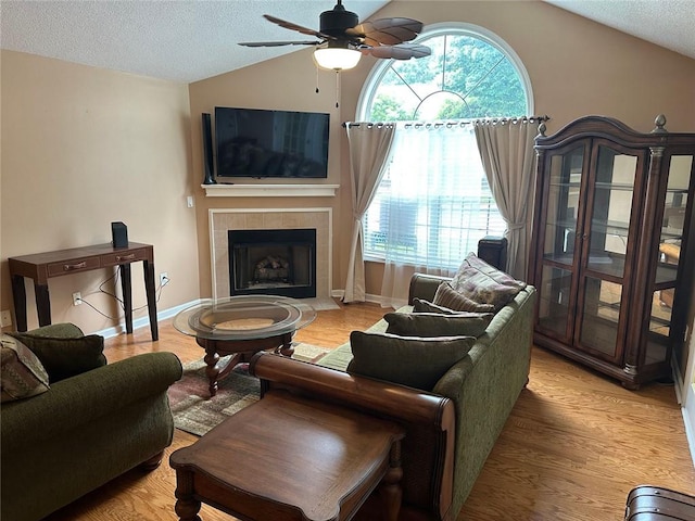 2191 Rockbridge Rd Unit 2603, Stone Mountain, GA 30087 - living room featuring vaulted ceiling, a textured ceiling, a ceiling fan, a fireplace, and light wood-style floors