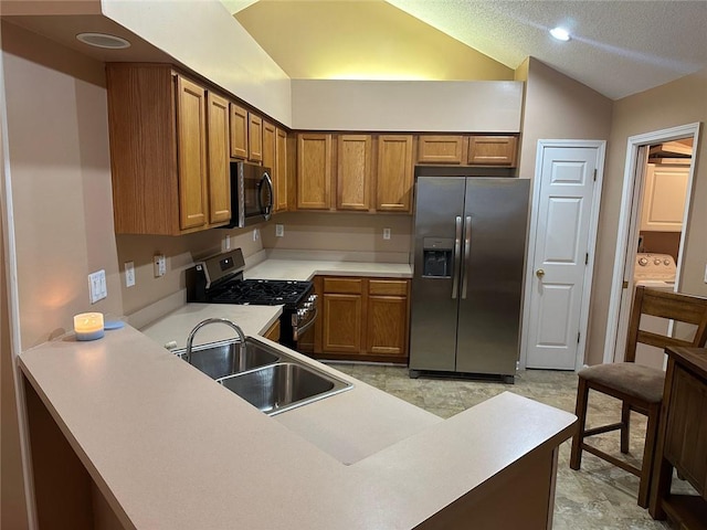 2191 Rockbridge Rd Unit 2603, Stone Mountain, GA 30087 - kitchen with appliances with stainless steel finishes, a sink, brown cabinetry, vaulted ceiling, and light countertops