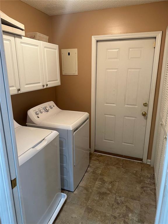 2191 Rockbridge Rd Unit 2603, Stone Mountain, GA 30087 - washroom featuring cabinet space, electric panel, independent washer and dryer, and a textured ceiling