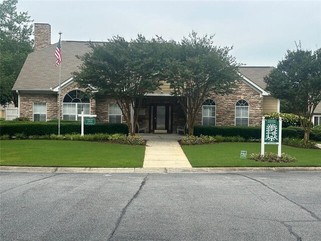 2191 Rockbridge Rd Unit 2603, Stone Mountain, GA 30087 - view of front of house featuring stone siding, a front lawn, and a chimney