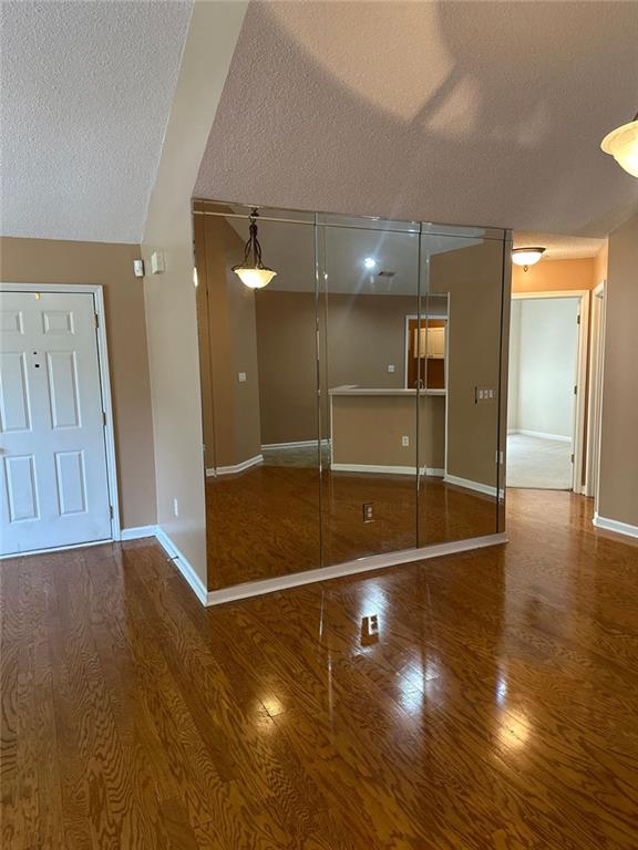 2191 Rockbridge Rd Unit 2603, Stone Mountain, GA 30087 - interior space featuring a textured ceiling, wood finished floors, and lofted ceiling