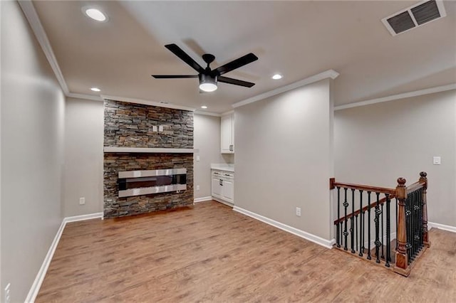 unfurnished living room with visible vents, a ceiling fan, light wood-style flooring, and crown molding