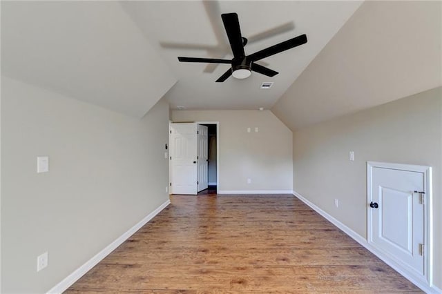 additional living space with a ceiling fan, visible vents, wood finished floors, baseboards, and lofted ceiling