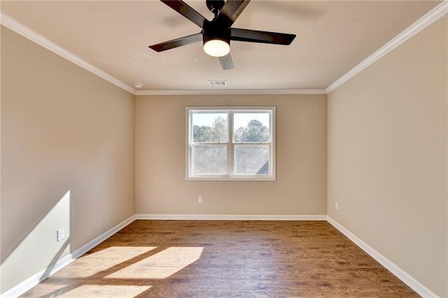 empty room featuring baseboards, visible vents, ornamental molding, and wood finished floors