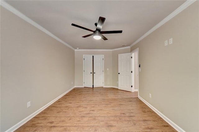 unfurnished bedroom featuring light wood-type flooring, ornamental molding, baseboards, and ceiling fan