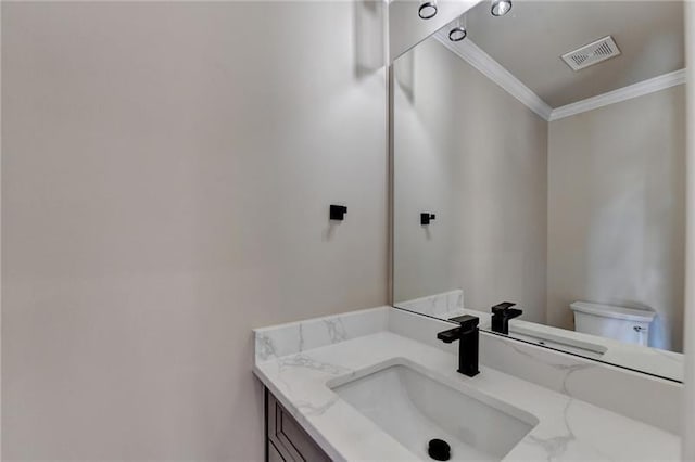 bathroom with visible vents, crown molding, toilet, and vanity