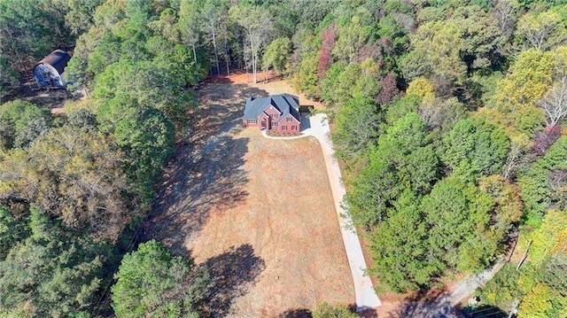 drone / aerial view featuring a wooded view