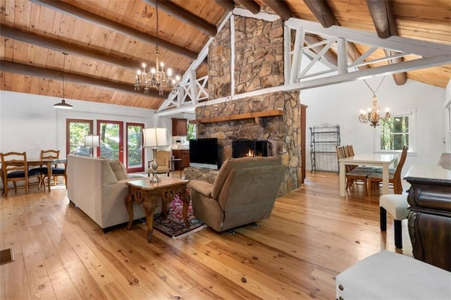 living room featuring a healthy amount of sunlight, wood ceiling, an inviting chandelier, and light hardwood / wood-style floors