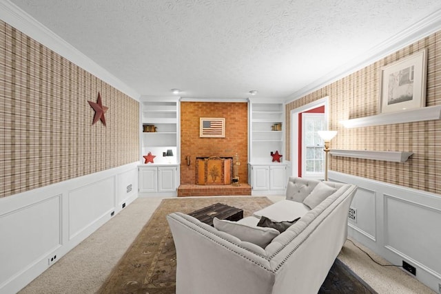 living room featuring crown molding, a large fireplace, built in shelves, a textured ceiling, and dark carpet