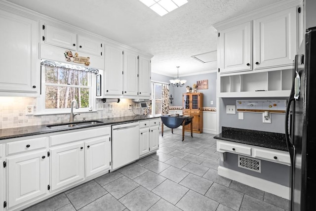 kitchen with hanging light fixtures, dishwasher, sink, and white cabinets