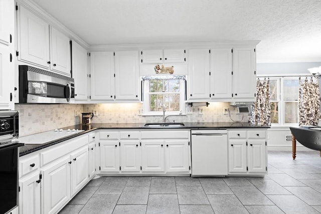 kitchen featuring sink, backsplash, white dishwasher, wall oven, and white cabinets