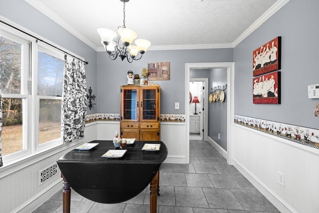 dining space with crown molding, a textured ceiling, a notable chandelier, and tile patterned floors