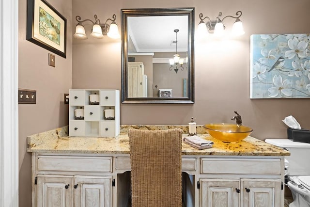 bathroom with vanity, ornamental molding, and toilet